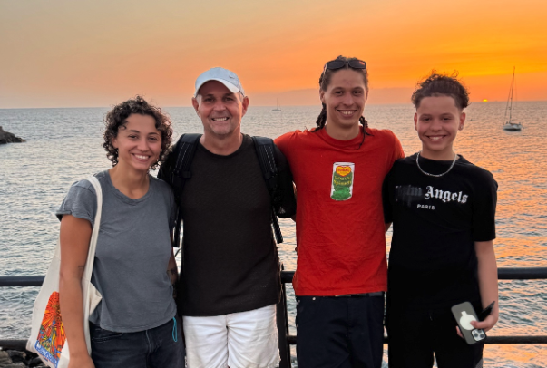 Steve Bolton with his three children by the sea at sunset, used on the multi-generational journey page.